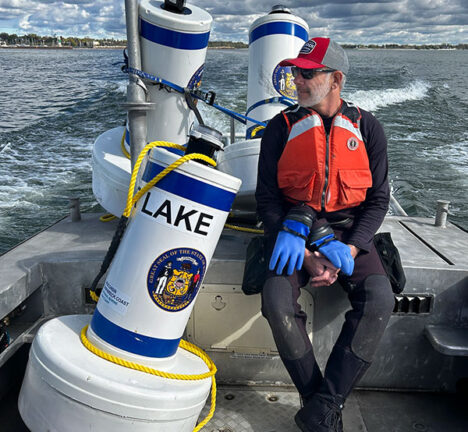 Man seated with a buoy on a boat.