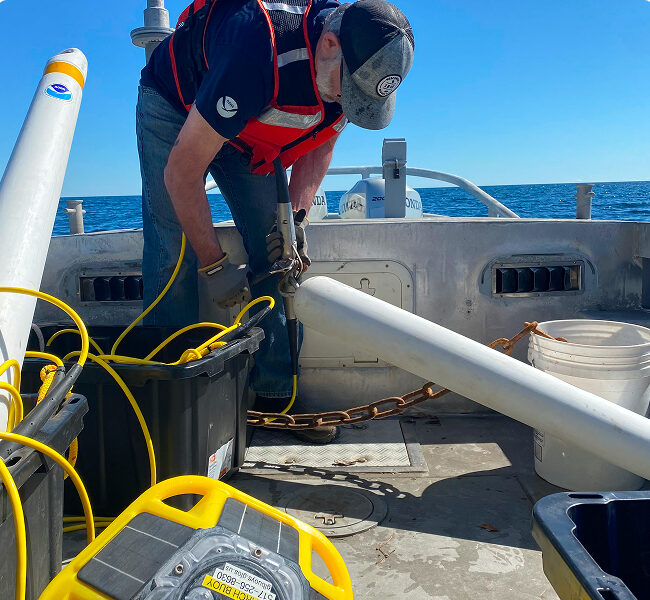 Man on a boat working with specialized equipment.