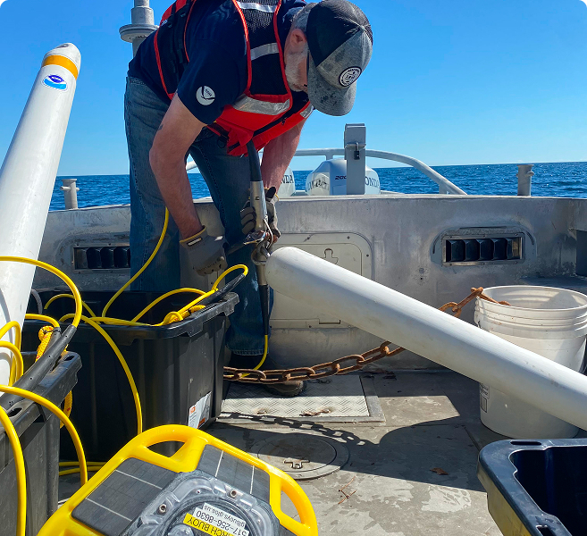 Man on a boat working with specialized equipment.