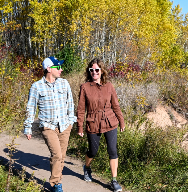 Two people walking along a path in nature.