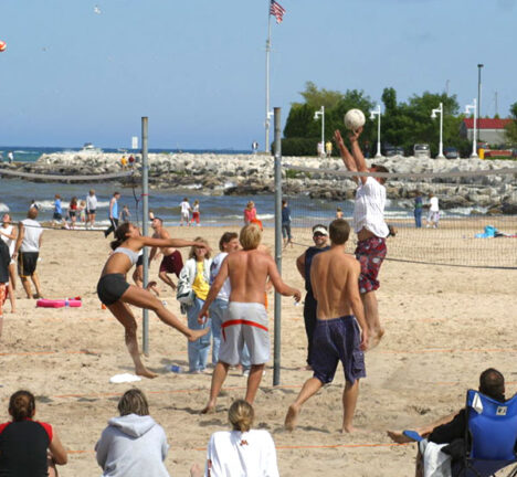 People playing volleyball on the beach.