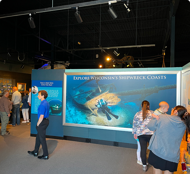 Museum exhibit with various people milling about.
