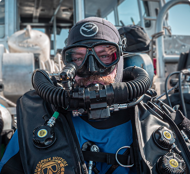 Portrait of a scuba diver in full gear standing on a boat.