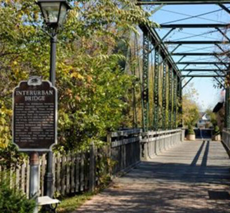 View of a walking trail leading onto a bridge.