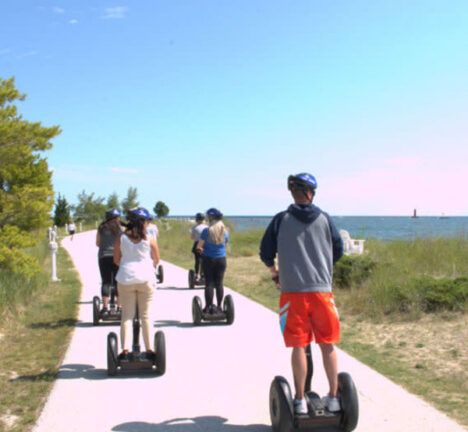 Group of people riding segways along the lakefront.
