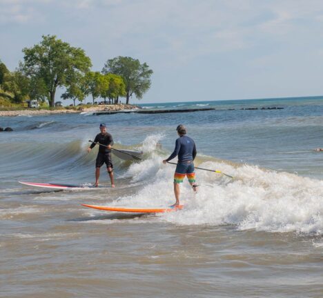 Two men surfing with paddles in Sheboygan.